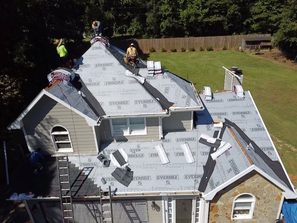 Aerial view — underlayment installation in progress on large home